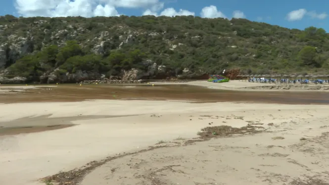 La torrentada arrasa la platja de Cala en Porter i engoleix arbres, para-sols, gandules i la torre de vigilància