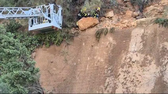 Els bombers retiren una roca a punt de caure a Port Adriano