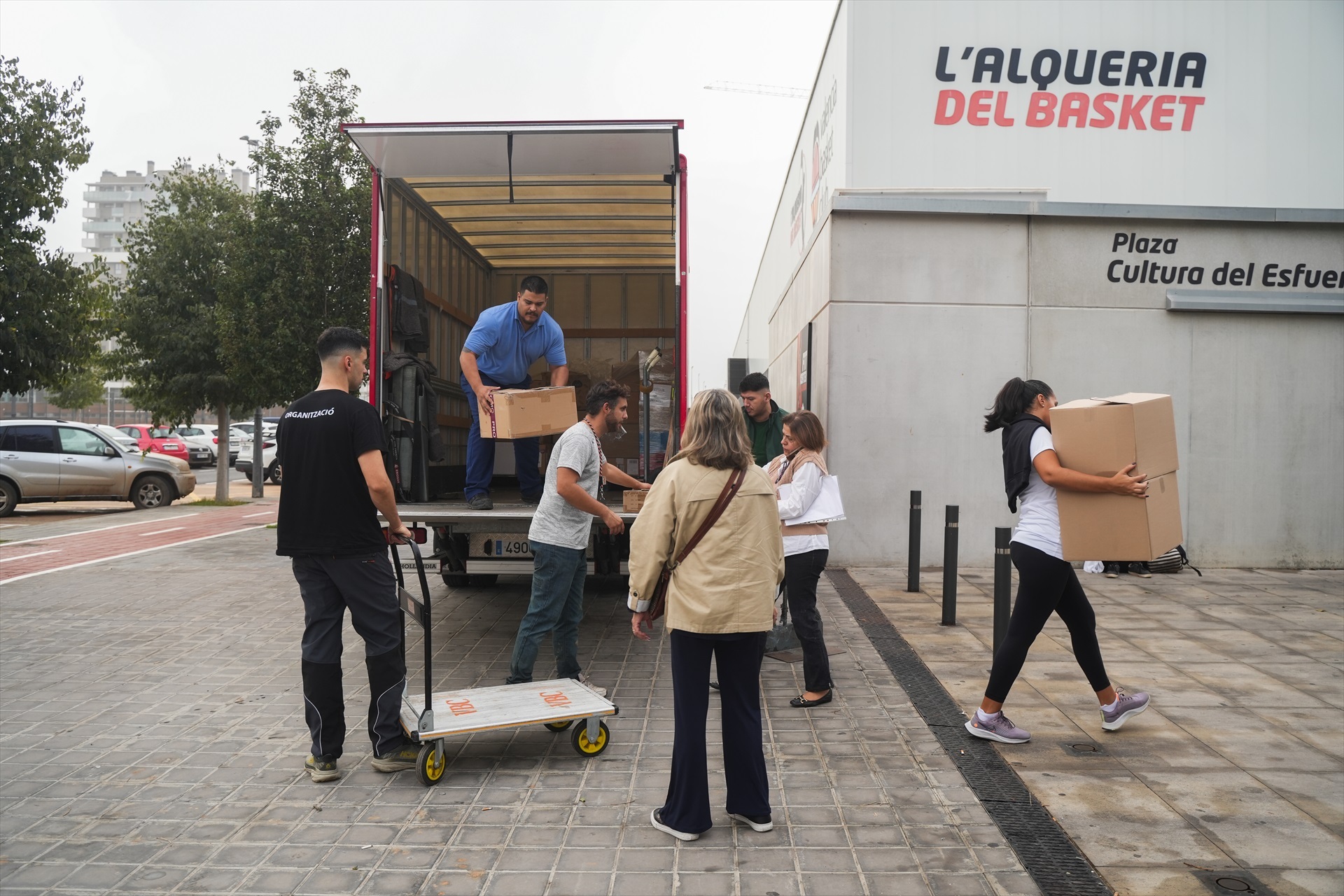 Un grup de persones descarrega capses amb roba, mantes i objectes de primera necessitat al pavelló de la Fonteta, a València. Jorge Gil / Europa Press