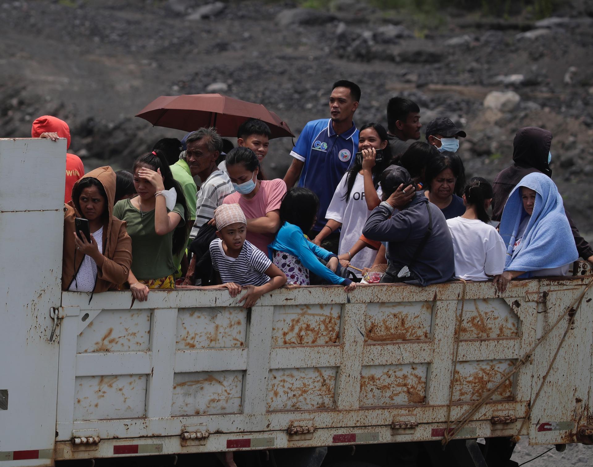 Els vilatans filipins que viuen als peus del volcà Mayon munten un camió durant una evacuació massiva a la ciutat de Guinobatan, província d'Albay, Filipines, el 09 de juny de 2023. Més de 20.000 residents que viuen al voltant de la zona de perill del volcà Mayon estan sent evacuats a les escoles, gimnasos i tendes de campanya enmig d'una erupció imminent. / EFE-EPA-FRANCIS R. MALASIG